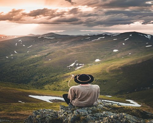 Relaxed person enjoying a peaceful sunset over the mountains